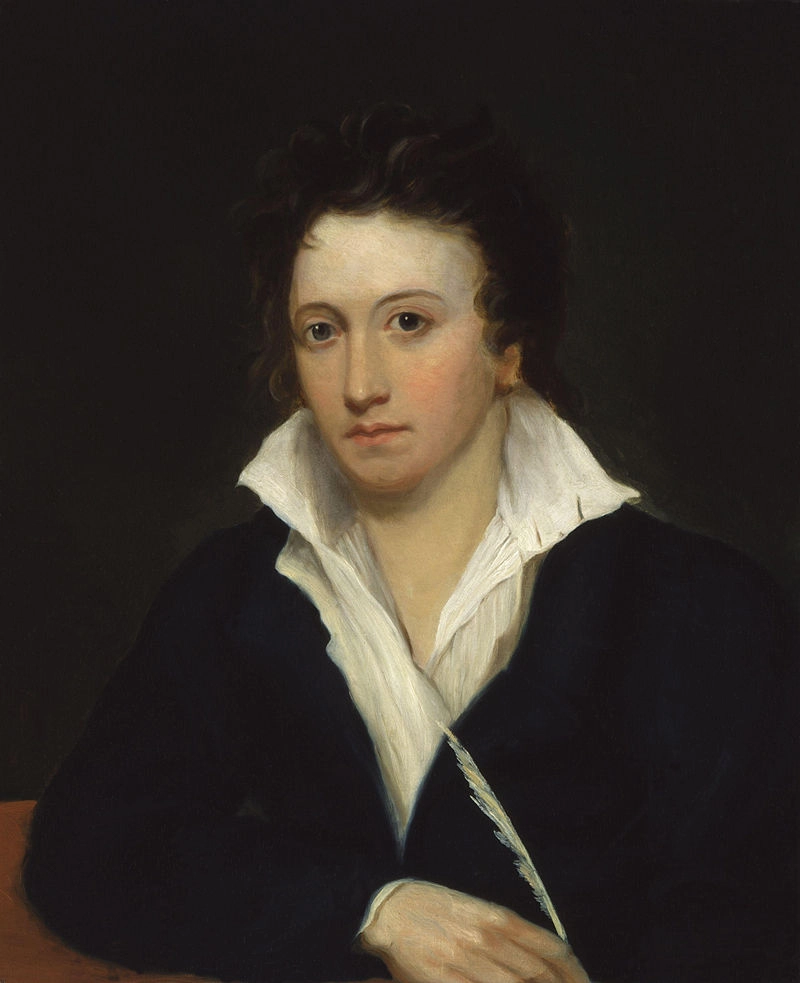 Portrait of Percy Bysshe Shelley by Alfred Clint, 1819. A man with curly hair and dark eyes, dressed in a black suit and white shirt, holding a quill.